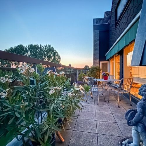 Balkon mit Sitzmöbeln und Pflanzen bei Sonnenuntergang in einer Maisonette-Eigentumswohnung in Krefeld.