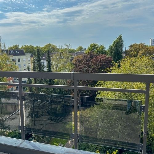 Freier Blick über die Dächer von Krefeld mit Grünflächen und Stadtansicht vom Balkon einer Maisonette-Wohnung.