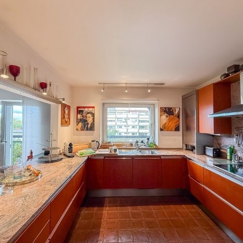 Helle Küche mit Granitoberflächen, großem Fenster und Blick ins Grüne in einer modernen Eigentumswohnung in Krefeld.