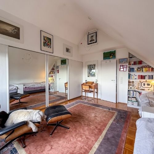 Gemütliches Schlafzimmer mit Leseecke, Einbauschränken und Einbauregalen in einer Maisonette-Eigentumswohnung.