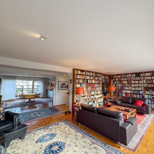 Helles Wohnzimmer mit großflächiger Bibliothek und Parkettboden in einer Maisonette-Eigentumswohnung in Krefeld.