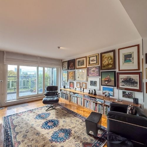 Wohnbereich mit Designer-Loungechair, Kunst an den Wänden und Zugang zur Terrasse einer Maisonette-Wohnung in Krefeld.