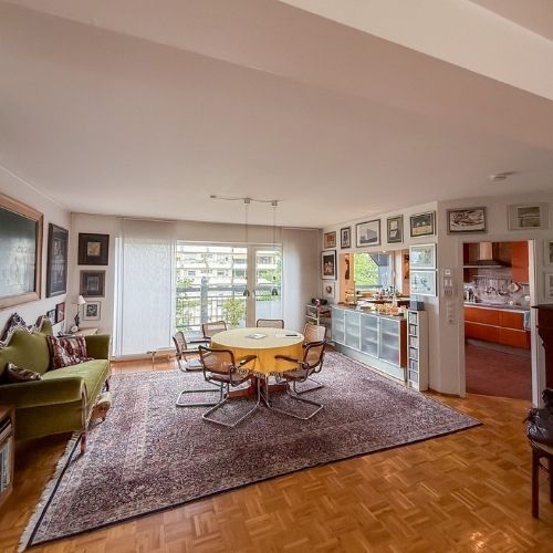 Offener Essbereich mit rundem Esstisch, Parkettboden und angrenzender moderner Küche in einer Maisonette-Eigentumswohnung.